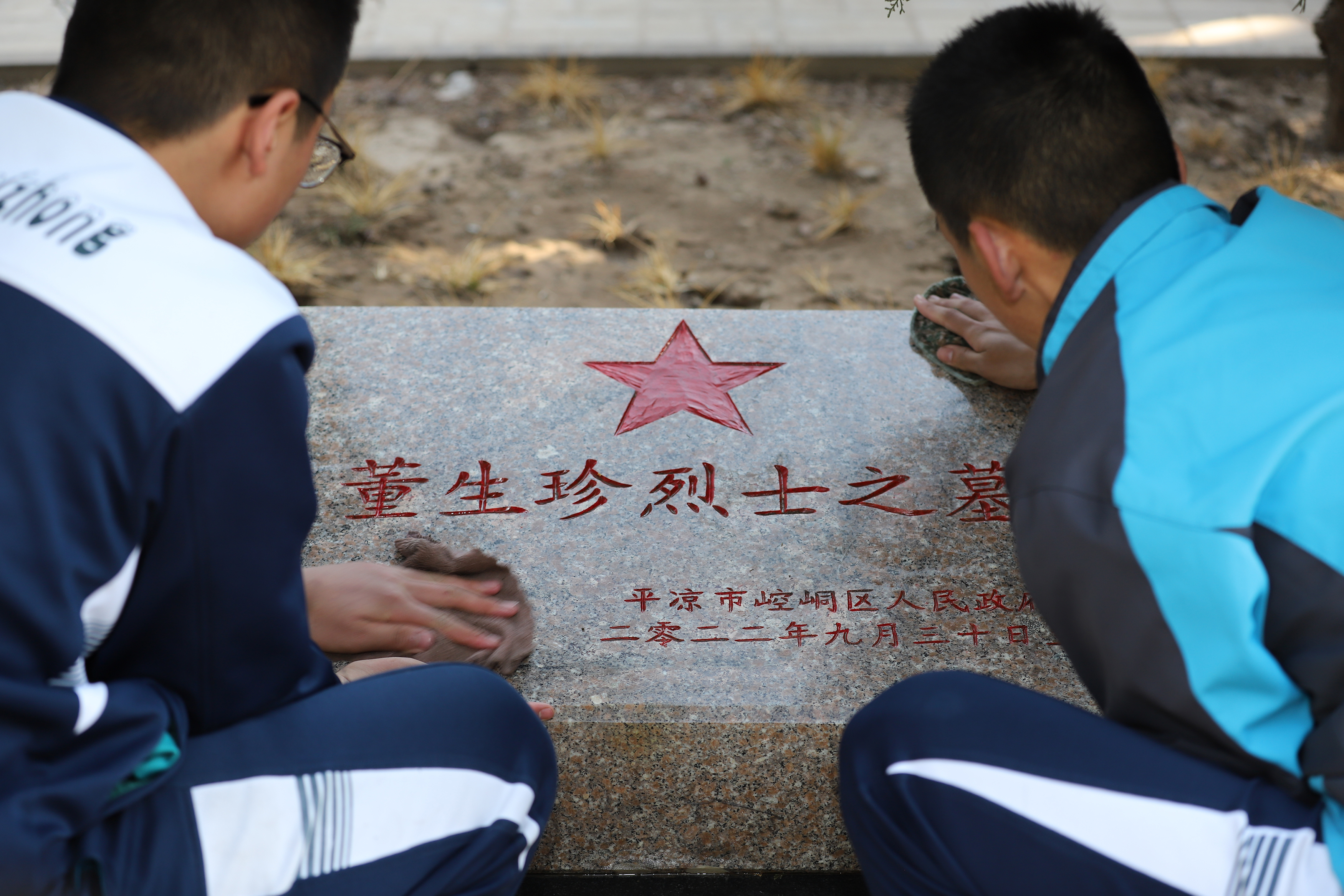 08——3月29日，甘肅省平?jīng)鍪械谒闹袑W(xué)學(xué)生在平?jīng)鍪辛沂苛陥@擦拭烈士墓碑。.JPG