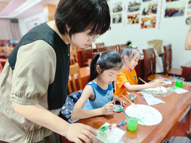 北侖區(qū)教師在社區(qū)假日學校指導(dǎo)學生畫畫 北侖區(qū)教育局供圖.jpg
