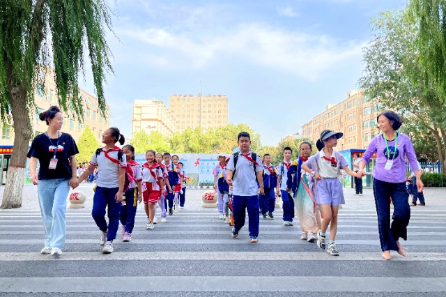 01 臨澤縣城關(guān)小學(xué)“紅燭先鋒”護(hù)學(xué)崗教師護(hù)送學(xué)生放學(xué)。謝靜 攝.jpg
