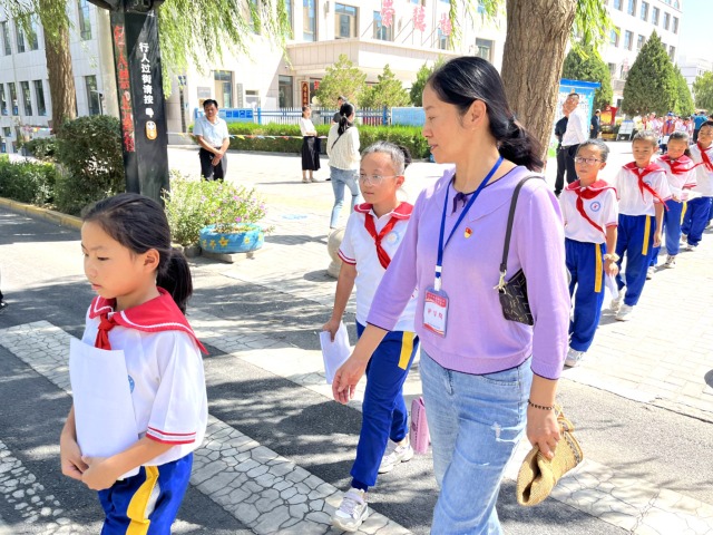 02 臨澤縣城關(guān)小學(xué)“紅燭先鋒”護(hù)學(xué)崗教師護(hù)送學(xué)生放學(xué)。謝靜 攝.jpg