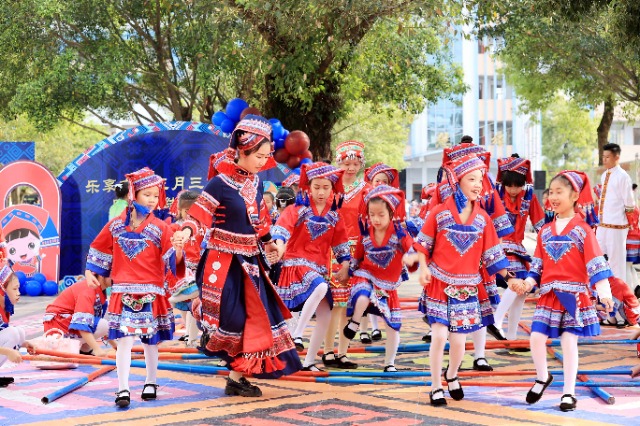圖4：4月9日，在廣西柳州市融安縣實(shí)驗(yàn)小學(xué)校園，一名老師帶著學(xué)生跳竹竿舞。（譚凱興 攝）.JPG
