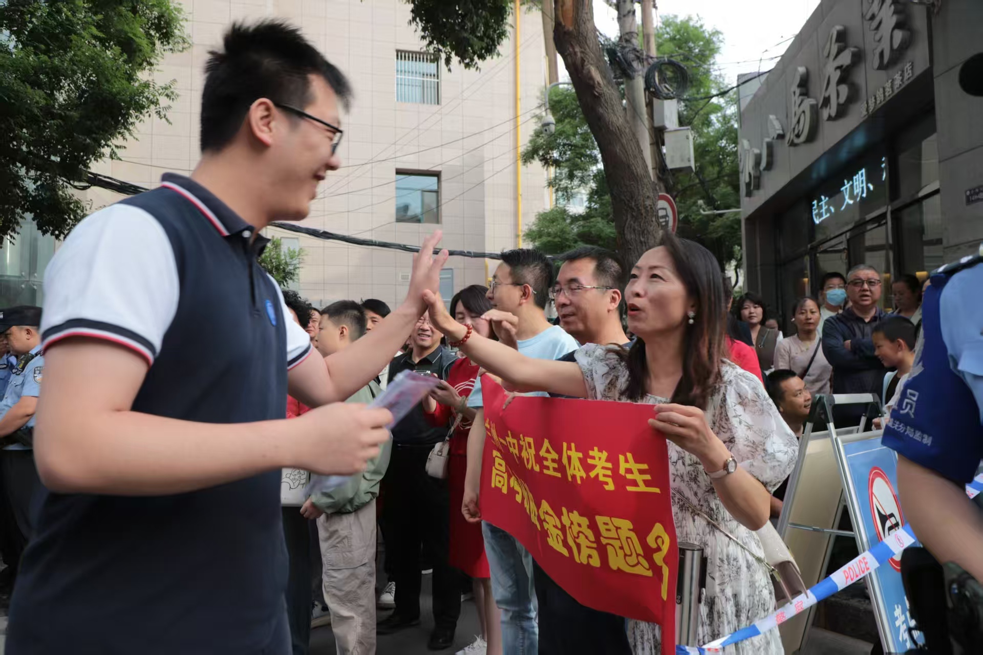首場(chǎng)考試開(kāi)考前，蘭州一中教師在考場(chǎng)外暖心陪考送祝福，鼓勵(lì)學(xué)生從容應(yīng)對(duì)。（馬綺徽 攝）.jpg